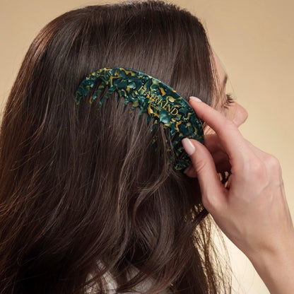 Person using HairKind Scalp Comb to gently distribute serum and stimulate scalp circulation