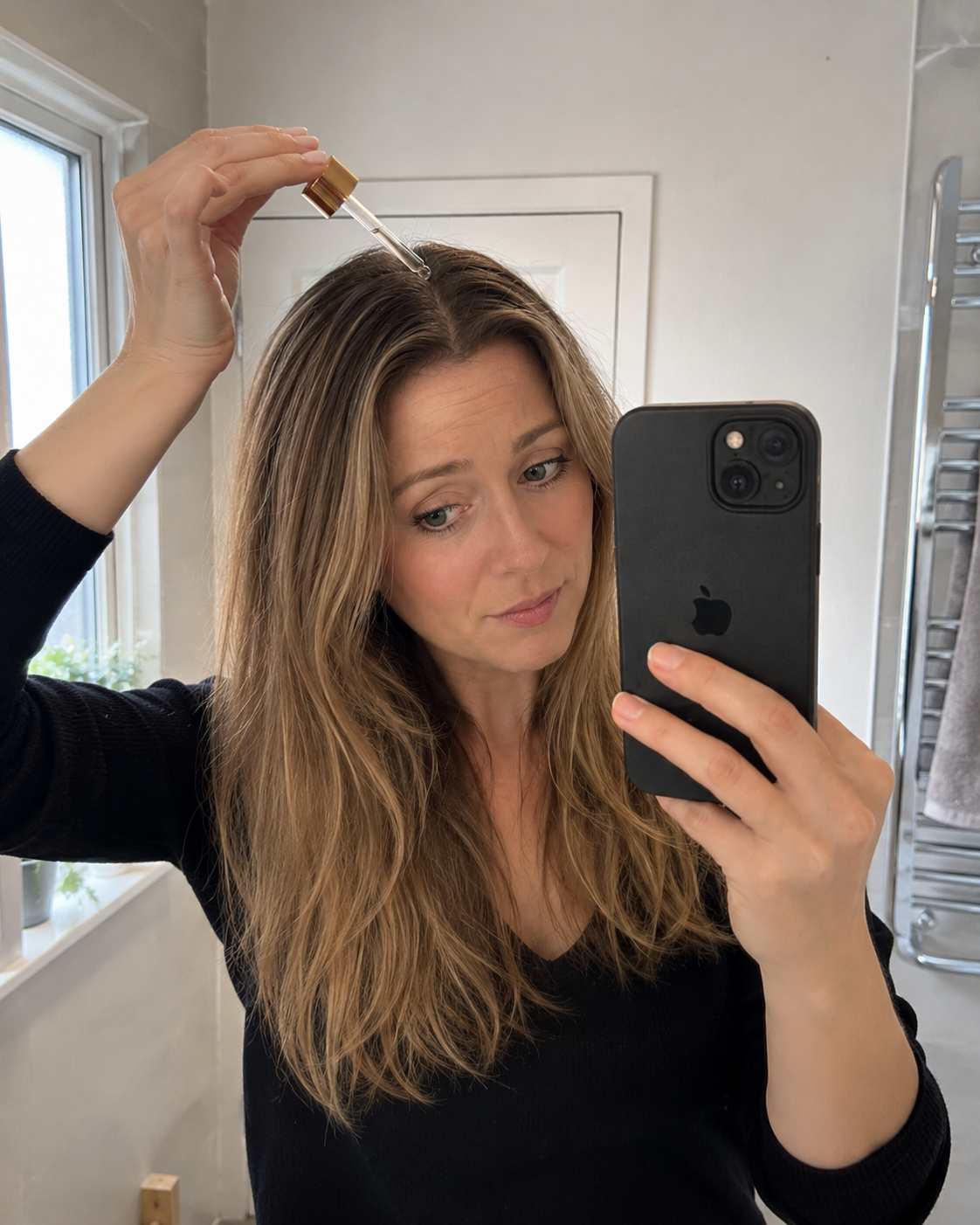 Emily applying scalp serum to her parting